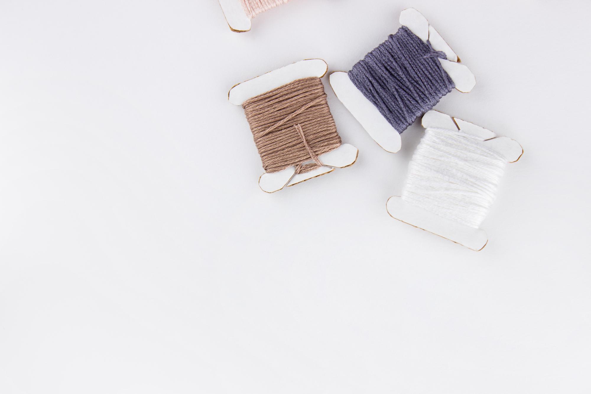 atelier worktable with threads and embroidered sample